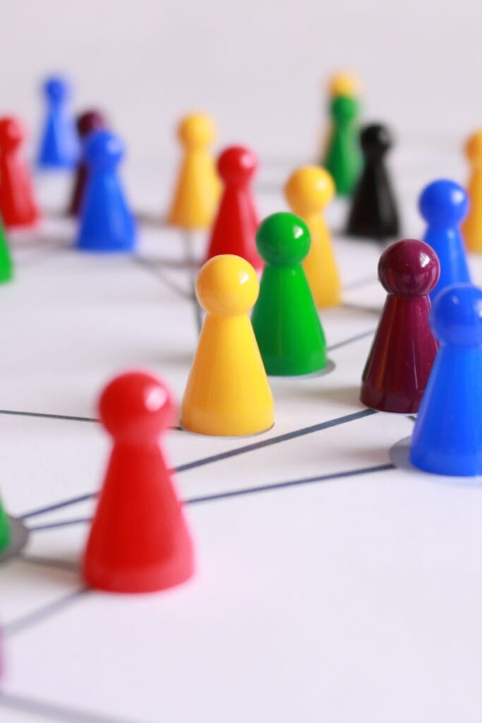 A strategic arrangement of colorful pawns connected on a game board, symbolizing networking and teamwork.